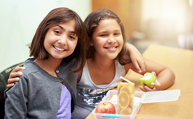 Image showing Girls, hug and portrait with lunch at school for recess, break or nutrition at table with diversity. Kids, face and smile at academy or relax with confidence, food or embrace for friendship and care