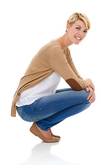 Image showing Happy woman, portrait and sitting in casual fashion or pose isolated on a white studio background. Young female person, model or blonde smile with denim jeans or clothing in relax on mockup space