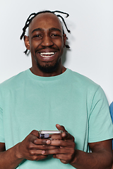 Image showing African American teenager engages with his smartphone against a pristine white background, encapsulating the essence of contemporary digital connectivity and youth culture