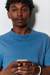 Image showing African American teenager engages with his smartphone against a pristine white background, encapsulating the essence of contemporary digital connectivity and youth culture