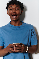 Image showing African American teenager engages with his smartphone against a pristine white background, encapsulating the essence of contemporary digital connectivity and youth culture