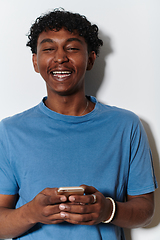 Image showing African American teenager engages with his smartphone against a pristine white background, encapsulating the essence of contemporary digital connectivity and youth culture