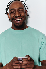 Image showing African American teenager engages with his smartphone against a pristine white background, encapsulating the essence of contemporary digital connectivity and youth culture