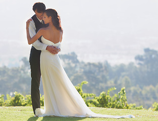 Image showing People hug, bride and groom at wedding, outdoor in nature for social event with love and commitment. Man, woman and marriage, couple celebrate with trust and care together on hill with life partner