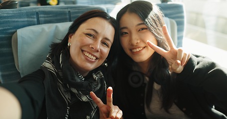 Image showing Women, peace sign and selfie on train, portrait and japan public transportation on metro bullet. Friends, emoji and happy face on fast vehicle on vacation trip and commute to tokyo city for adventure
