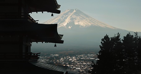 Image showing Chureito Pagoda, Mount Fuji and view of city in morning with temple, trees and blue sky on travel. Japanese architecture, culture and spiritual history with mountain, snow and calm Asian landscape.