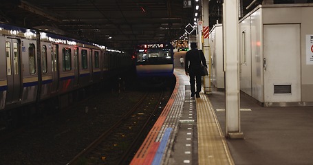 Image showing Train, platform and man at station for travel, commute or journey on railway transportation. Public transport, underground railroad service and back of person walking for departure, arrival or subway