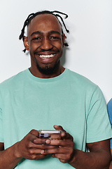 Image showing African American teenager engages with his smartphone against a pristine white background, encapsulating the essence of contemporary digital connectivity and youth culture