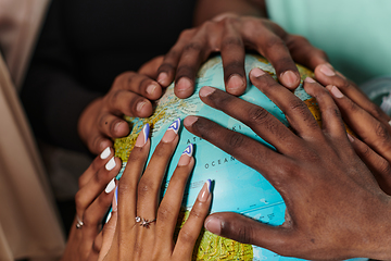 Image showing Close up of diverse teenagers' hands delicately exploring a globe, capturing the essence of curiosity and exploration in their tactile engagement with geographical knowledge