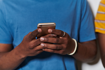 Image showing African American teenager engages with his smartphone against a pristine white background, encapsulating the essence of contemporary digital connectivity and youth culture