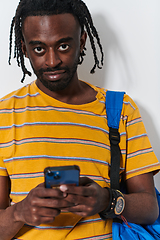 Image showing African American teenager engages with his smartphone against a pristine white background, encapsulating the essence of contemporary digital connectivity and youth culture