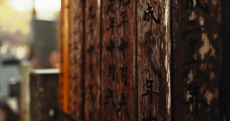 Image showing Japan, writing and wood with Japanese, spiritual and pillars with sign on a urban road outdoor. Travel, path and Asian culture with ancient structure with history in Hanamikoji Street in Kyoto