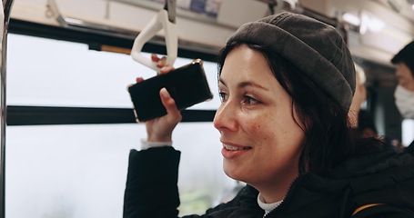 Image showing Woman, smartphone and thinking in train, travel and hand holding handle for balance, safety and memory. Girl person and phone with ideas, smile or public transport on railway infrastructure in Tokyo