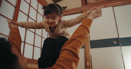 Image showing Baby, airplane game and mom in a Japanese family home with toddler, love and happy fun. House, mother and young girl with smile, living room and flying with bonding together with a child and mama