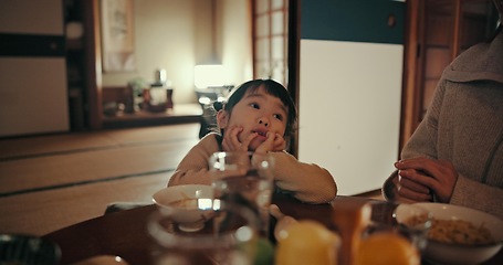 Image showing Asian child, family home and bored at dinner with parents for food, tired or night in dining room. Japanese kid, nutrition and diet with thinking, annoyed or frustrated by table at apartment in Tokyo