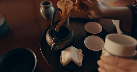 Image showing Hands of woman in traditional Japanese matcha, drink and relax with mindfulness, respect and service. Girl at calm tearoom with teapot, zen culture and ritual at table for tea ceremony from above.