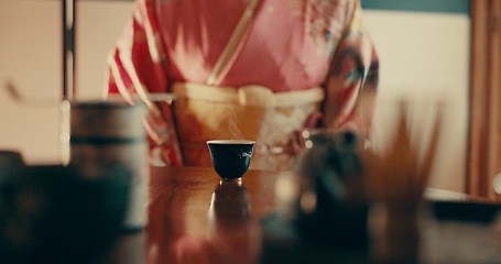 Image showing Woman with traditional Japanese tea cup on table, kimono and relax with mindfulness, respect and process. Girl at calm tearoom with matcha drink, Asian zen culture and social ritual ceremony in home.