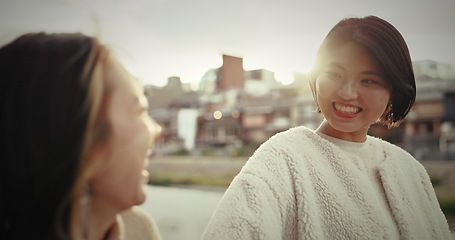 Image showing Japanese woman, walking and happy in city by water canal and happiness for bonding in town. Friends, smile and together in wellness by suburban neighborhood, care and lens flare in tokyo for sunlight