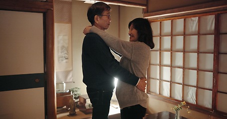 Image showing Mature couple, dancing and home with love, smile and happiness with weekend break, hug and bonding together. Japanese people, man and woman embrace, apartment and cheerful with peace and support