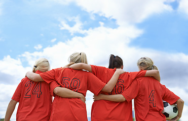 Image showing Woman, hug and back of soccer team ready for sports match, game or outdoor practice with blue sky. Rear view of female person or group of football players standing in unity with ball in nature