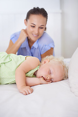 Image showing Smile, sleeping and mother with baby on bed for bonding, relax and sweet cute relationship. Happy, love and young mom watching girl child, kid or toddler taking a nap in bedroom or nursery at home.