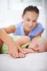 Image showing Hands, sleeping and mom with baby on bed for bonding, relax and sweet cute relationship. Happy, smile and young mother watching girl child, kid or toddler taking a nap in bedroom or nursery at home.