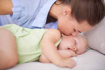 Image showing Kiss, sleeping and mother with baby on bed for bonding, relax and sweet cute relationship. Happy, smile and young mom watching girl child, kid or toddler taking a nap in bedroom or nursery at home.
