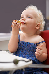 Image showing Kid, high chair and eating cupcake, food and breakfast sweets at home in kitchen. Young child, hungry toddler and muffin dessert, sugar and pastry snack for cute adorable girl in house in the morning