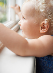 Image showing Girl, window and baby with smile standing against glass or wall in family home learning to walk. Happy, female toddler and young cute kid at house with childhood development or natural growth alone