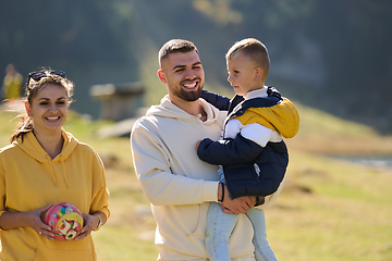 Image showing A modern family, along with their son, revels in the joy of a muddy day in nature, running and playing together, encapsulating the beauty of a healthy and active lifestyle