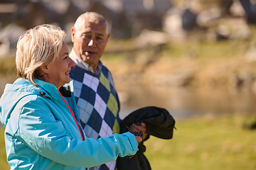 Image showing Elderly couple strolling through the breathtaking beauty of nature, maintaining their vitality and serenity, embracing the joys of a health-conscious and harmonious lifestyle