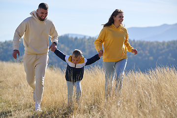 Image showing A modern family, along with their son, revels in the joy of a muddy day in nature, running and playing together, encapsulating the beauty of a healthy and active lifestyle