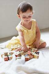 Image showing Baby, girl and child, blocks as toys for learning, playing at home for education and alphabet. Growth, early childhood development and toddler with educational activity, playtime and montessori