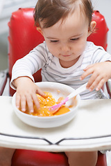 Image showing Baby, high chair and eating food in bowl for meal, nutrition or healthy porridge at home. Young, cute and adorable little child, kid or toddler playing with snack for hunger, vitamins or nutrients