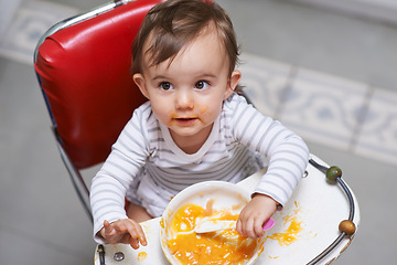 Image showing Child eating, high chair and food, nutrition and health for childhood development and wellness. Healthy, growth and toddler person at home, vegetable or fruit, hungry baby with lunch or dinner meal