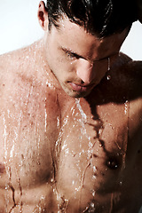 Image showing Serious, man in shower to relax and washing body for hygiene, morning wellness and skin routine. Grooming, skincare and face of male model with muscle cleaning in water, self care and calm bathroom.