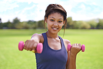Image showing Woman, portrait and dumbbells outdoor for training with smile for workout, exercise or fitness on sports field. Athlete, person and happy for physical activity or healthy body on grass with equipment