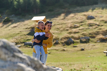 Image showing A mother and son create cherished memories as they playfully engage in outdoor activities, their laughter echoing the joy of shared moments and the bond between parent and child