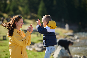 Image showing A mother and son create cherished memories as they playfully engage in outdoor activities, their laughter echoing the joy of shared moments and the bond between parent and child