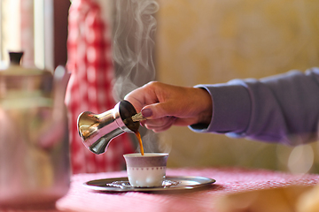 Image showing Elderly woman savors the serenity of the morning as she enjoys a cup of coffee on the porch of her rustic cottage, finding solace in the simplicity of nature and contemplative moments