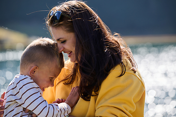 Image showing A mother and son create cherished memories as they playfully engage in outdoor activities, their laughter echoing the joy of shared moments and the bond between parent and child