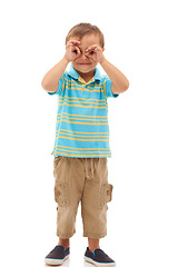 Image showing Hands, binoculars and portrait of kid search, find or inspection in white background of studio. Curious, vision and child with gesture to spy for research, knowledge and learning from sightseeing