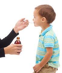 Image showing Hands, medicine and spoon for child in studio, care and thinking with drinking by white background. Kid, mother and bottle for healthcare, pharmaceutical product and helping sick boy in profile