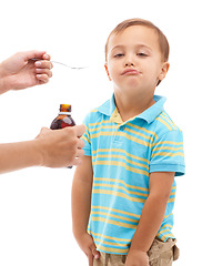 Image showing Hands, medicine bottle and spoon for kid in studio, health or portrait with fluid by white background. Boy, mother and liquid for healthcare, pharmaceutical product or helping sick child for wellness