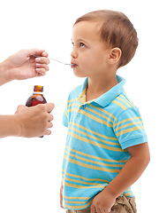 Image showing Hands, medicine bottle and kid drink in studio, health or profile for spoon in mouth by white background. Boy, parent and liquid for healthcare, pharma product or helping sick child for immune system