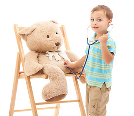 Image showing Boy kid, teddy bear and stethoscope in studio for playing doctor, listening and wellness by white background. Child, healthcare game and development with plush toys, medical check or consultation