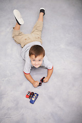 Image showing Child, portrait and cars or toys play for learning growth or development, happiness or weekend. Kid, face and smile on home carpet with transportation vehicle for education game, creativity or fun