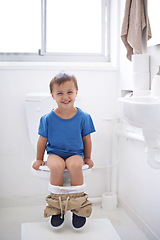 Image showing Boy kid, potty training and toilet with sitting, diaper and happy in portrait for learning, development or progress. Child, family home and back in bathroom with smile, hygiene or solution with nappy