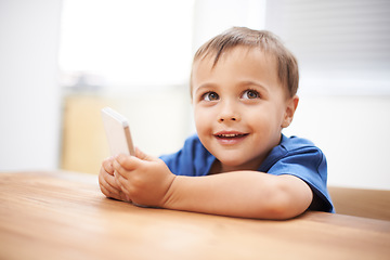 Image showing Child, boy and phone at home, happiness and communication with online technology. Table, streaming and educational app for e learning, games and excited for development, watching and digital