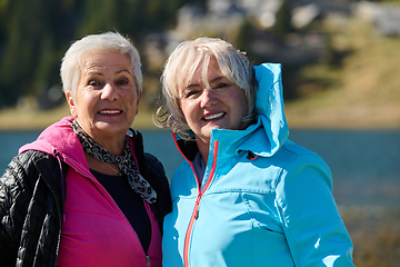 Image showing Senior women hikers standing on mountain enjoying a trekking day - Smiling climbing tourists enjoying holidays and healthy lifestyle - Freedom, success sport concept